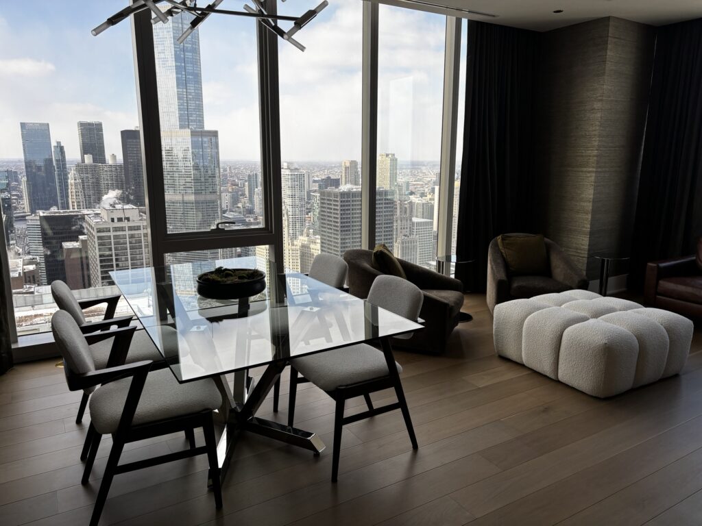 Spotless high-rise dining area with glass table and city skyline views.