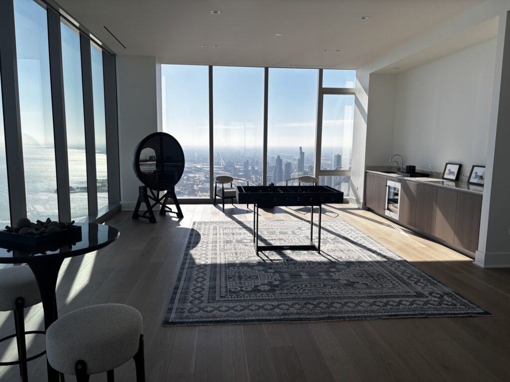 Clean, sunlit lounge with floor-to-ceiling windows and city skyline.