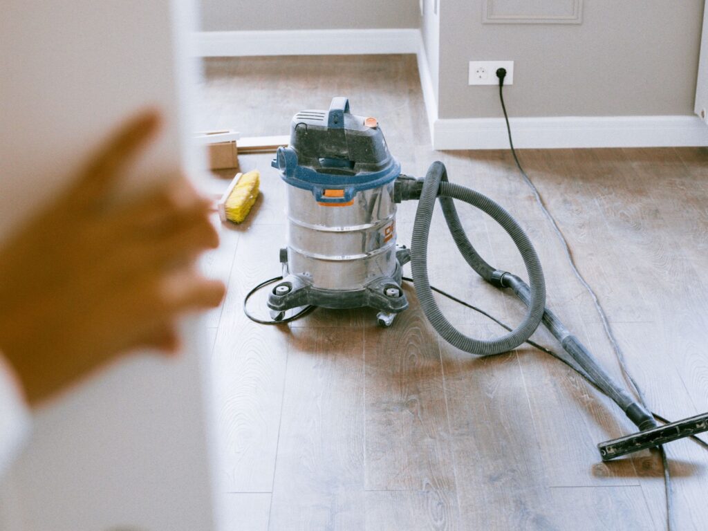 Vacuum and broom ready to clean an empty room after a move.